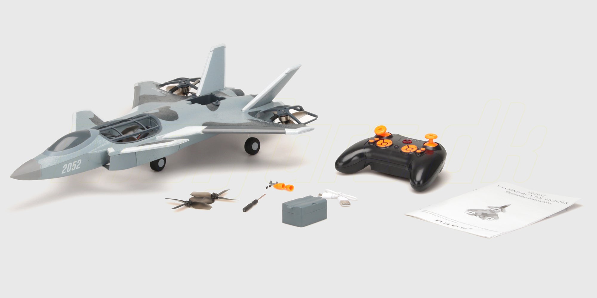 Grå Fighter Jet Brushless fjernstyret fly vist i sin kasse med tilhørende fjernbetjening og tilbehør.