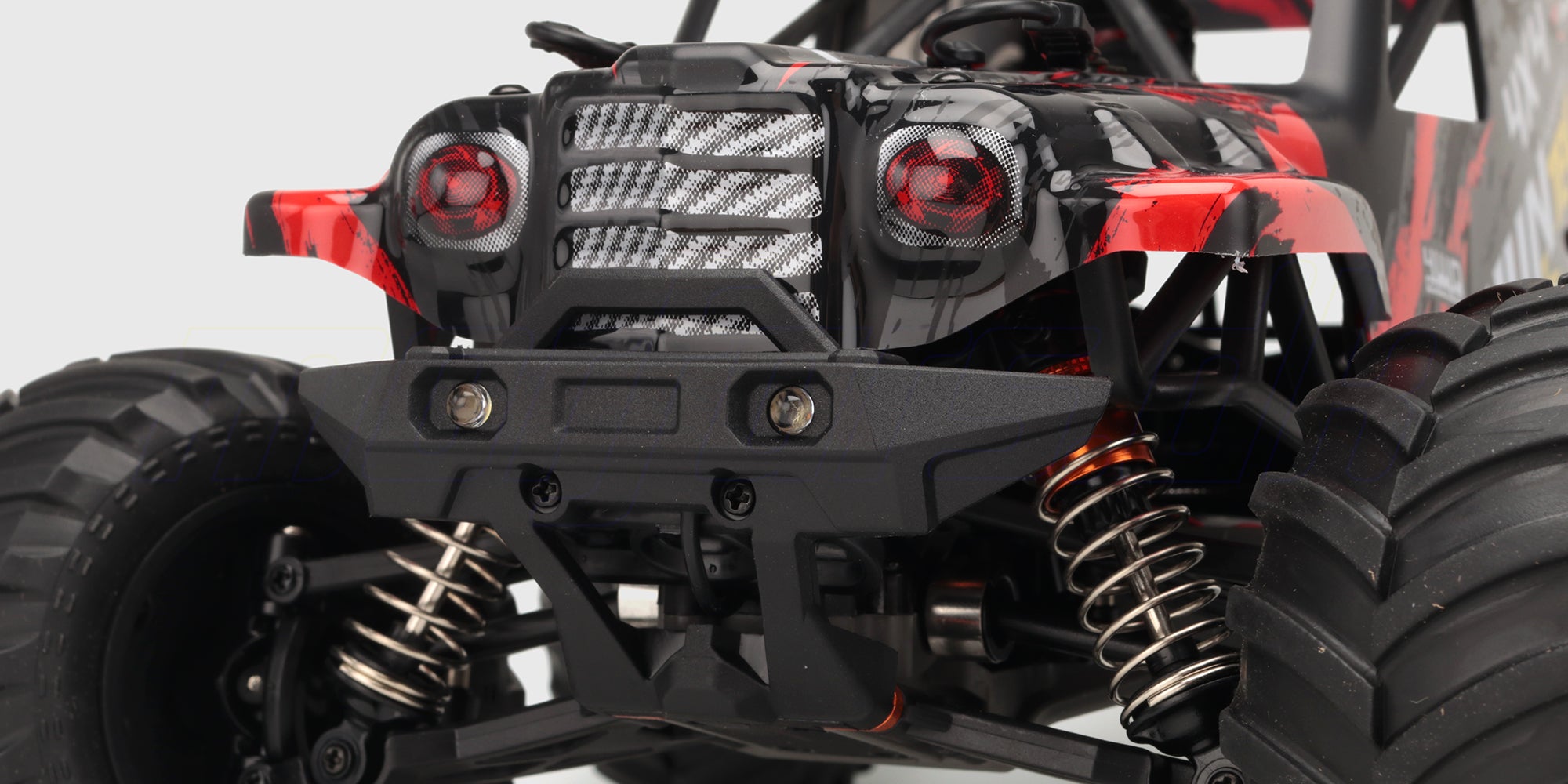 Rød Hurricane XL Monster Truck med store offroad-hjul i fuld fart gennem støvet terræn.
