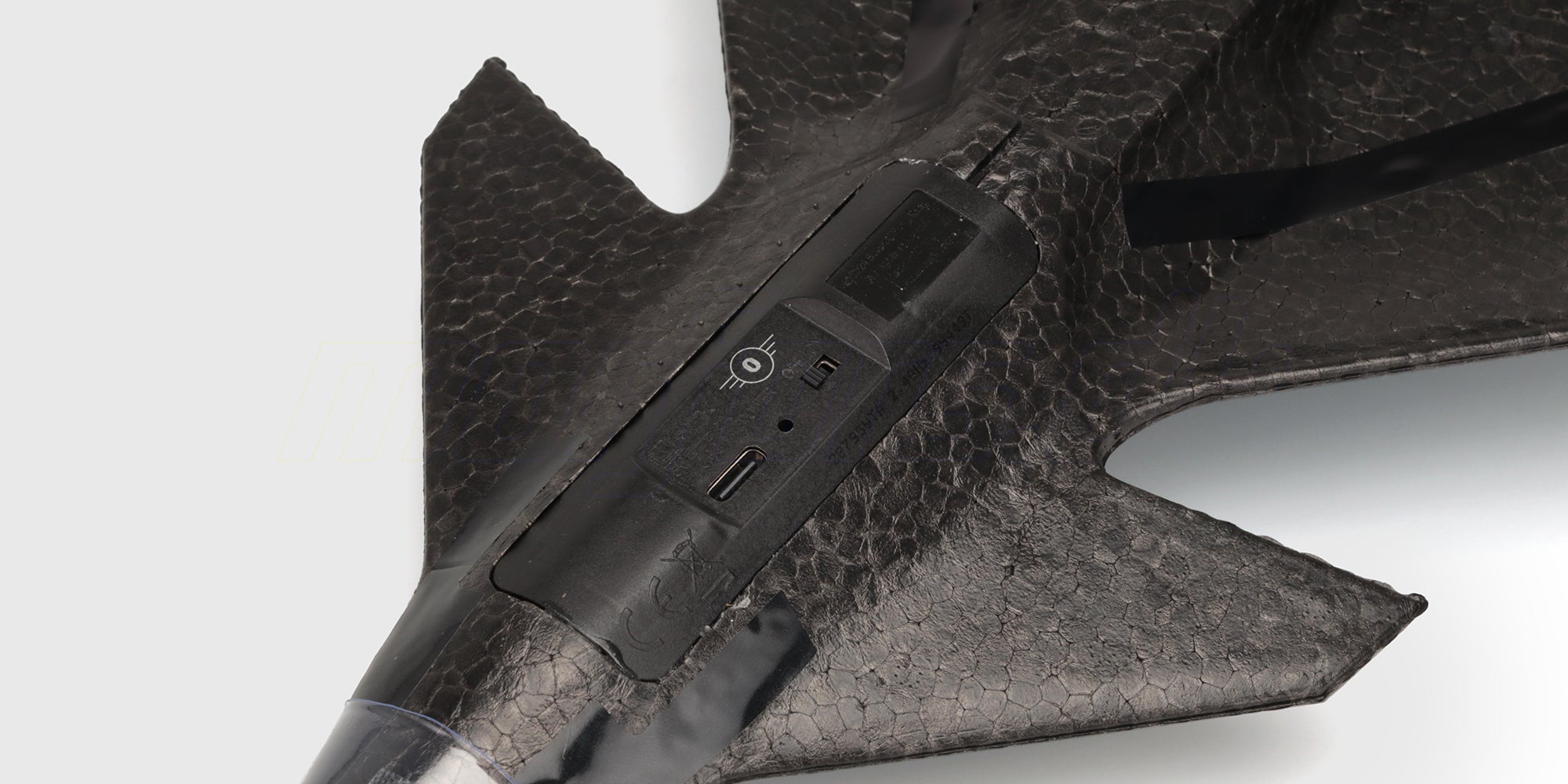 Tændknap og USB-C-ladeport på undersiden af Revo Stunt