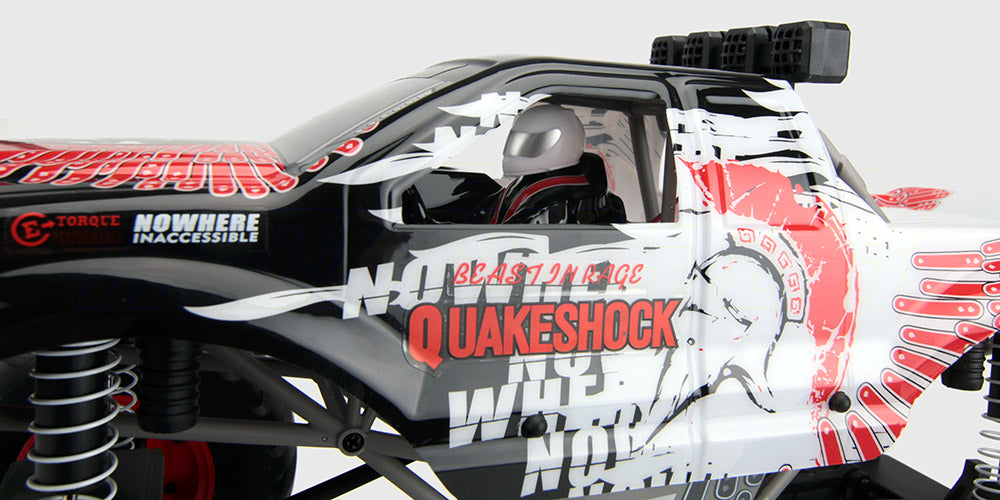 Sort og rød Quakeshock monster truck til offroad kørsel i terræn med store dæk og robust affjedring.
