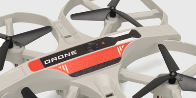 Hvid Chameleon FPV Drone med kamera og beskyttelsesramme omkring propellerne
