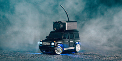 Lille Mini FPV Car i fuld fart på en vej med realistisk sløret baggrund og skarpt fokus.