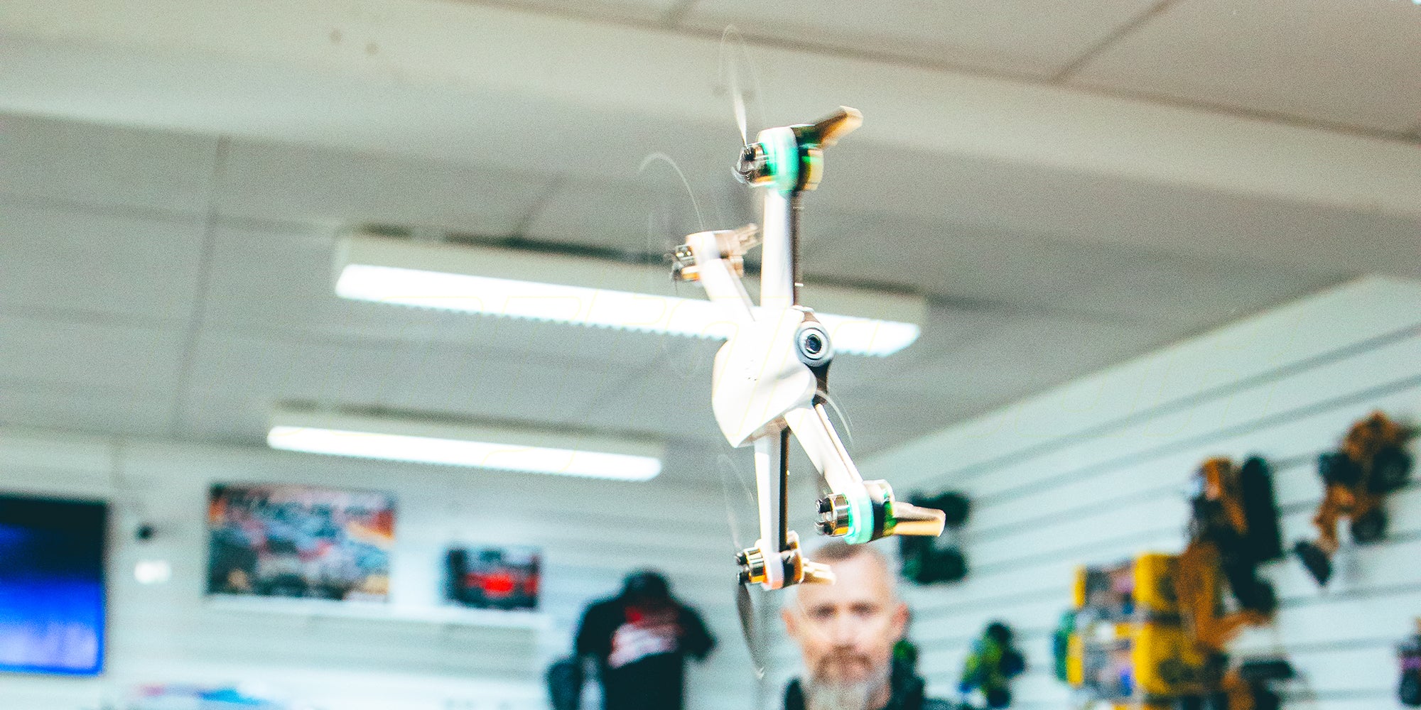 Sort Drone ST16B med propelbeskyttere i luften klar til at lave loops udendørs.