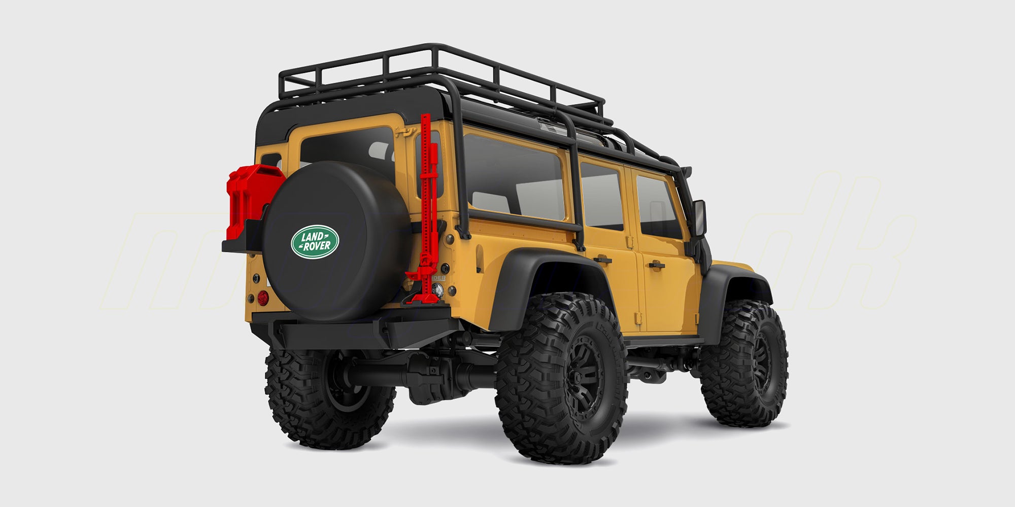 Sandfarvet Traxxas TRX-4M Defender crawler i skala 1:18 kører gennem mudret terræn i naturen.