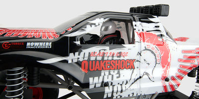 Sort og rød Quakeshock monster truck til offroad kørsel i terræn med store dæk og robust affjedring.