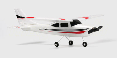 Hvidt fjernstyret Cessna 182 fly med blå detaljer klar til start på græsset.